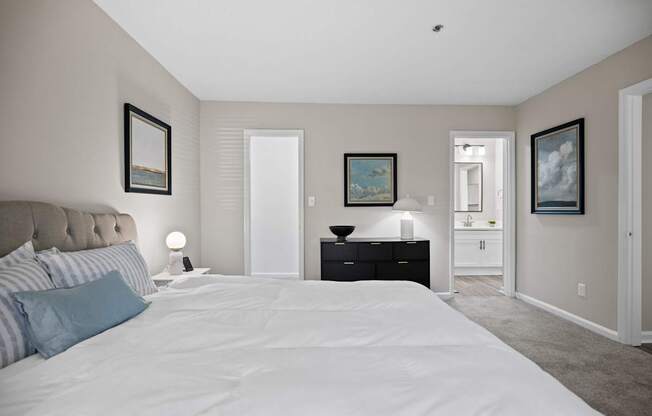 A bedroom with a large bed and a painting on the wall.