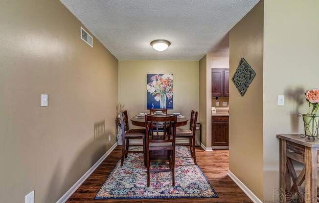 a dining room with a table and chairs and a kitchen