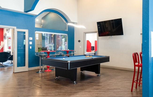 a game room with a pool table and a tv