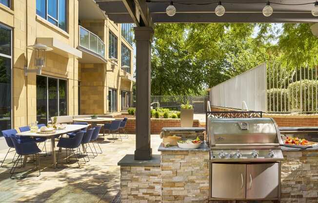 a patio with a grill and tables with chairs