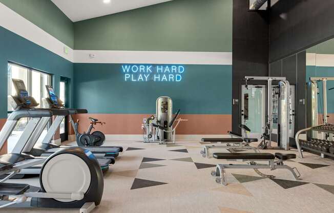 A gym with a variety of equipment including treadmills, stationary bikes, and weight machines. at Bridge at Tech Crossing, Austin