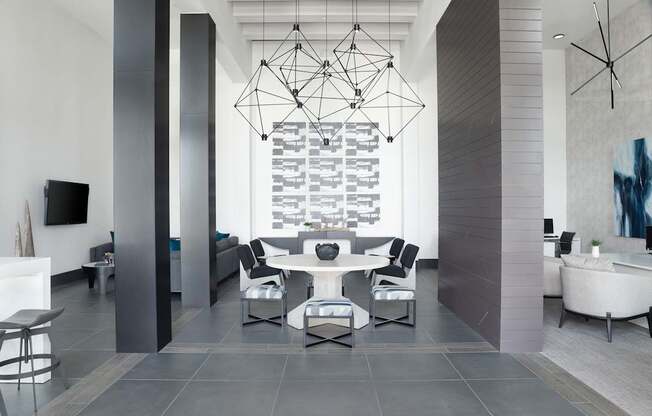 A modern living room with a large window, a TV, and a unique geometric light fixture.