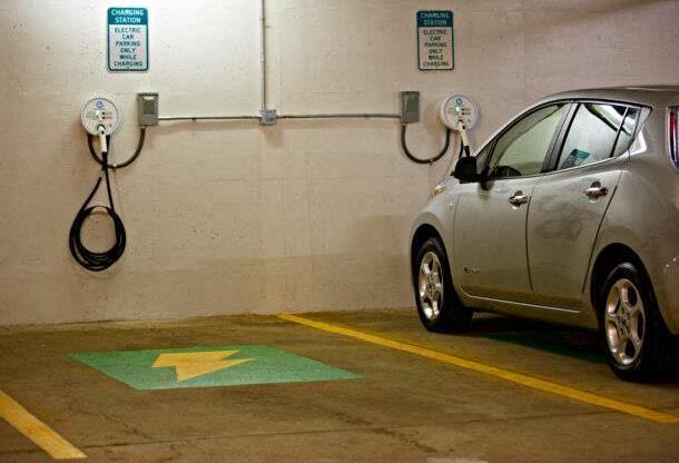 A car is parked in a parking spot with a charging station.