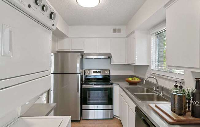 A modern kitchen with stainless steel appliances and white cabinets.