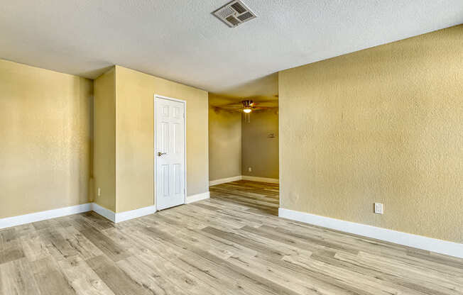 the living room and dining room of an empty house with wood floors