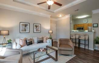 A living room with a couch, chair, and a glass table.