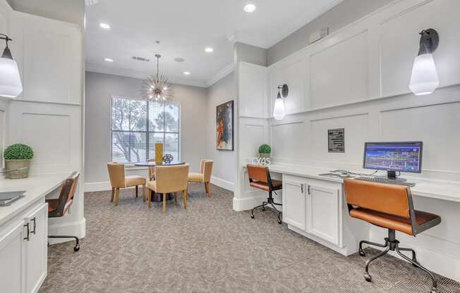 an office with a desk and chairs and a table with a computer