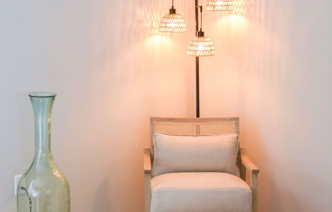 a small chair and a vase in a bedroom