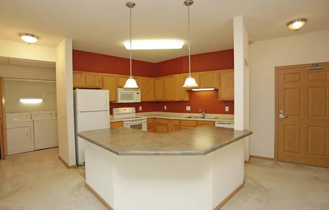 A kitchen with a white island and brown cabinets.