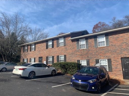 a brick building with two cars parked in front of it