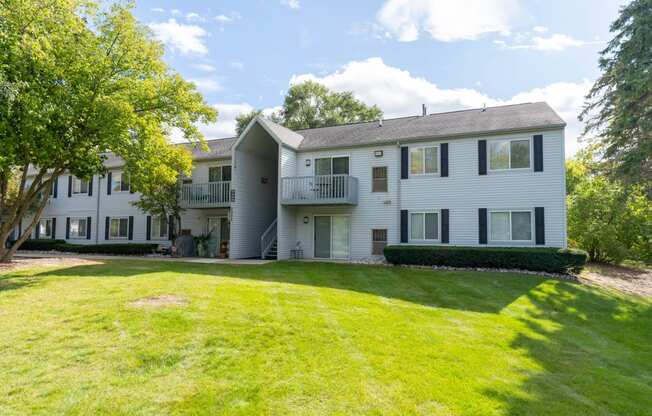 white apartment building with green grass and trees