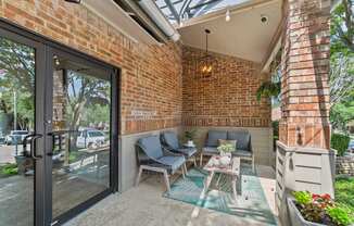 A patio with a glass door and a brick wall.