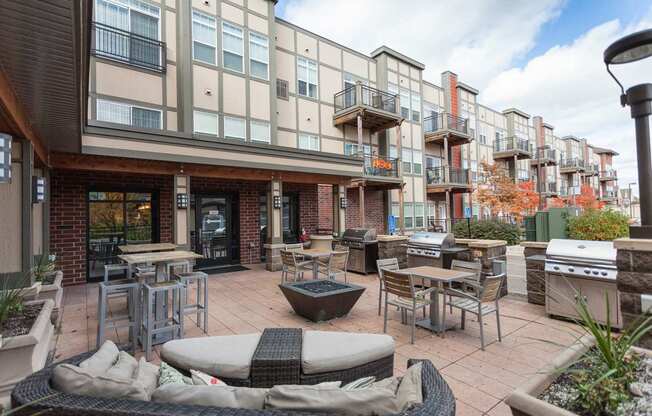 A patio area with tables and chairs in front of a building.