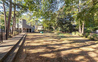 A backyard with a wooden deck and a green lawn.