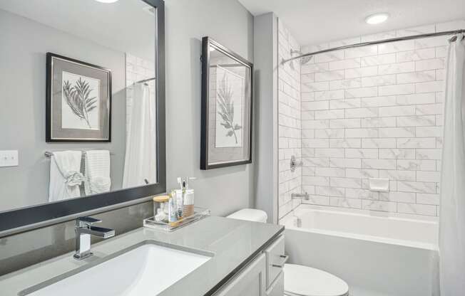 a white bathroom with a shower and a sink