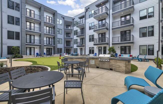 an outdoor patio with tables and chairs at an apartment complex
