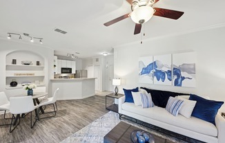 a living room with a couch and a ceiling fan