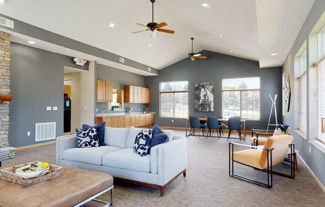 the clubhouse living room with gray walls, a stone fireplace, and seating