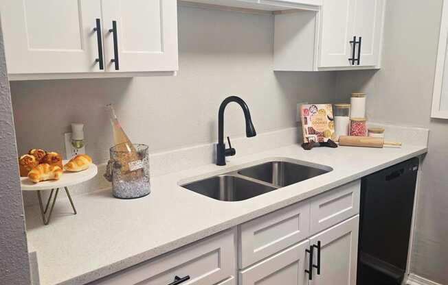 a kitchen with white cabinets and a sink and a rug