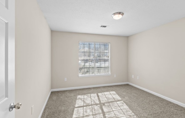 an empty room with carpet and a window