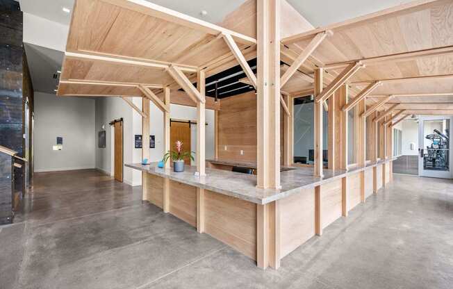A large open space with a wooden beam ceiling and concrete flooring.