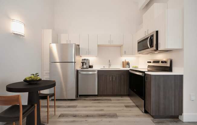 a kitchen with stainless steel appliances and a small table with chairs  at Track 281 Apartments, California, 95811