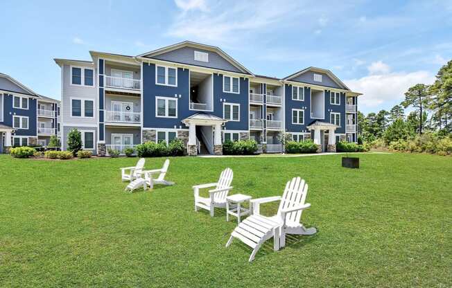 a large lawn with chairs and a building in the background