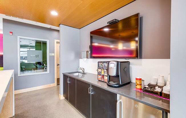 A coffee machine and a flat screen TV mounted on the wall.