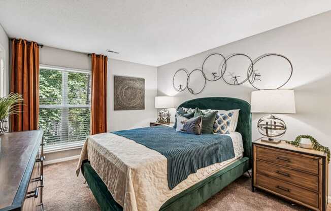 A bedroom with a bed, nightstand, and window.