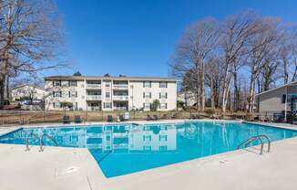 A large swimming pool in front of an apartment complex at Madison Woods apartments in Greensboro, NC.