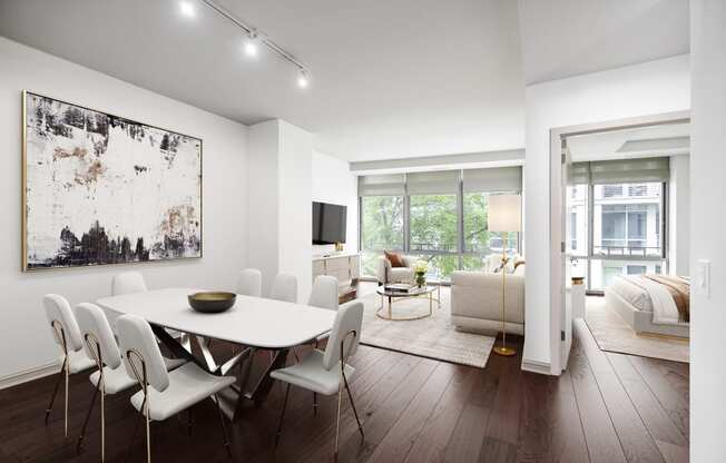 a dining area with a white table and chairs and a tv on the wall