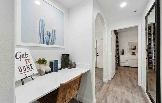 a home office with white walls and hardwood flooring