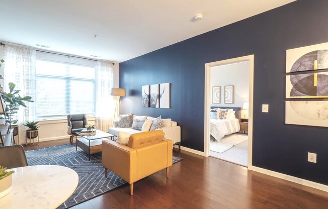 a living room with a blue accent wall and a yellow couch