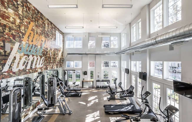 a gym with a brick wall and lots of windows