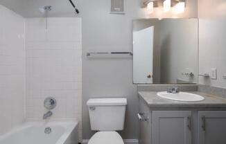 A white toilet sits next to a white sink in a bathroom.