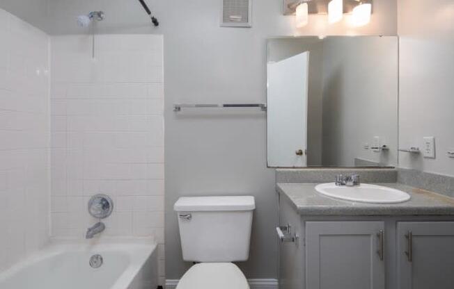 A white toilet sits next to a white sink in a bathroom.