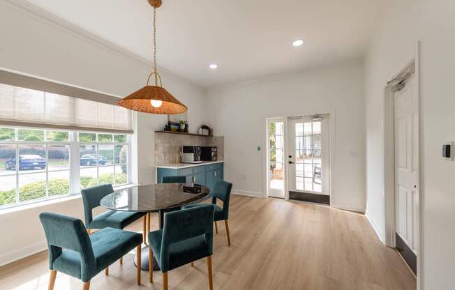 A dining room with a table and chairs.