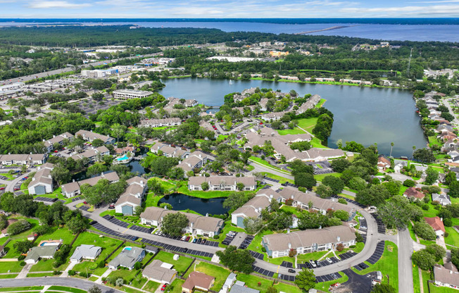 an aerial view of a neighborhood with a lake in the background