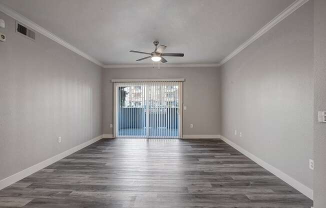 an empty living room with a ceiling fan
