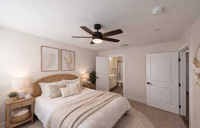 A bedroom with a bed, nightstands, and a ceiling fan.