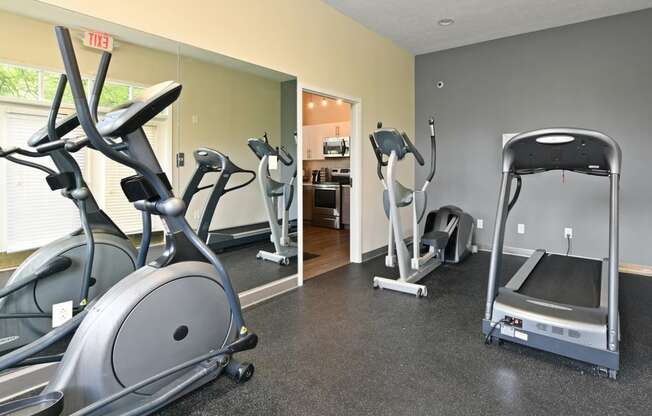 a gym with treadmills and ellipticals at the enclave at woodbridge apartments