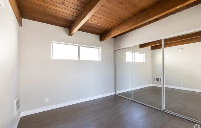 an empty living room with sliding glass doors to a closet