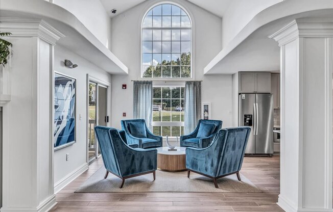 a living room with two blue chairs and a large window