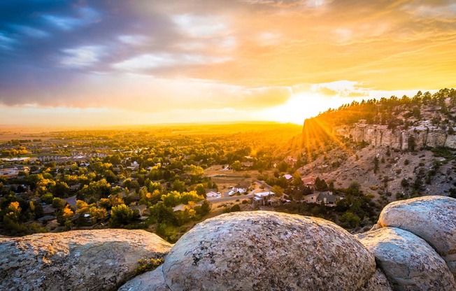 a view of the sunset over a city from a rocky hill at Rock Creek, Billings, MT