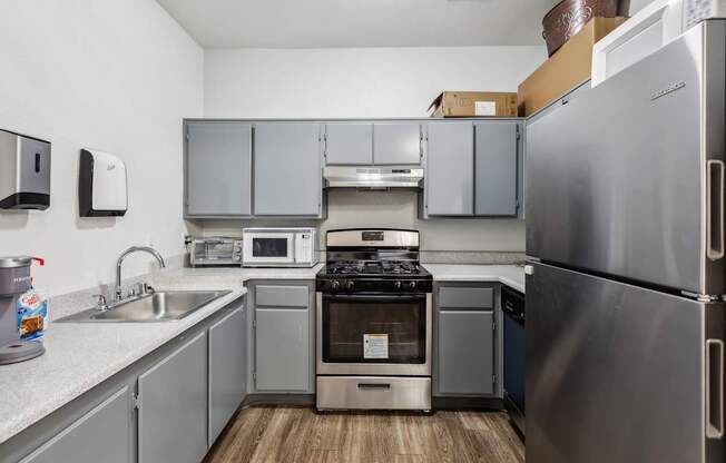 A kitchen with a stainless steel refrigerator, microwave, and oven.