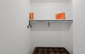 a brown bench in a white room with a shelf