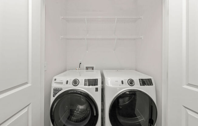 a white washer and dryer in a white closet