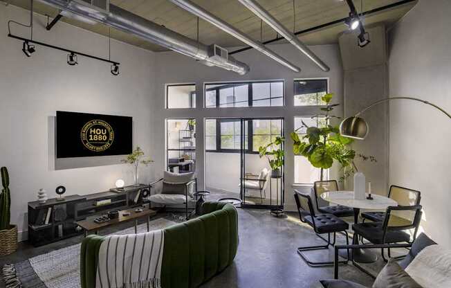 A living room with a couch, chairs, and a television displaying the text "HOLLYWOOD 1939".