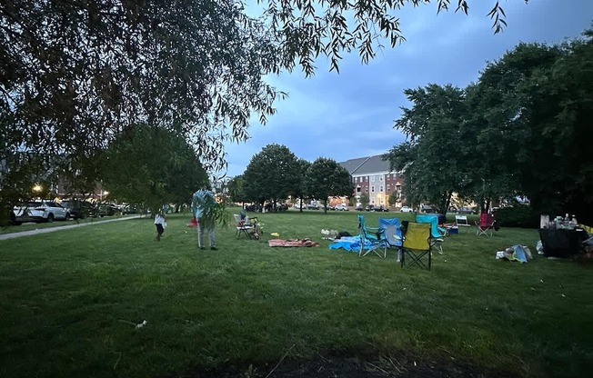 A park with people and trees under a blue sky.