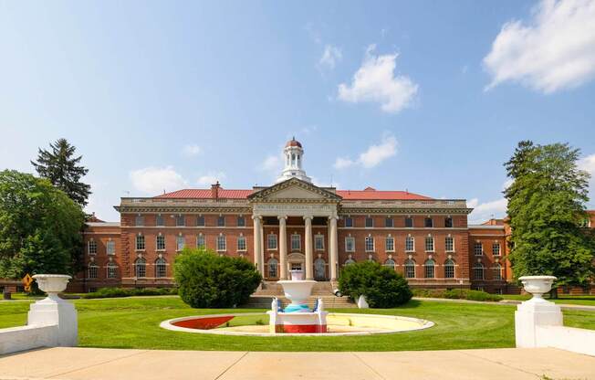A large red brick building with a white column in front.